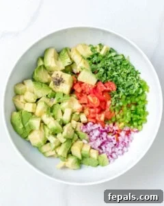 All avocado salsa ingredients added to a bowl, showing the initial step of mixing.