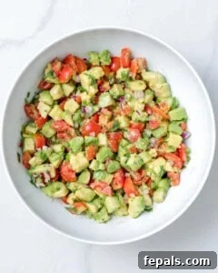 The finished salsa, made with avocado and tomatoes, beautifully presented in a bowl.