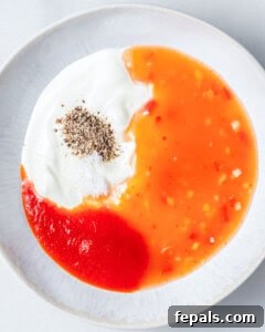 Ingredients for Bang Bang sauce are added to a dish before mixing.