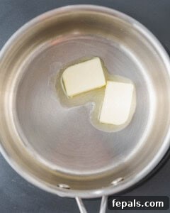 Melted butter in a pan with flour ready to be added, showing the beginning of the roux for Bechamel sauce.