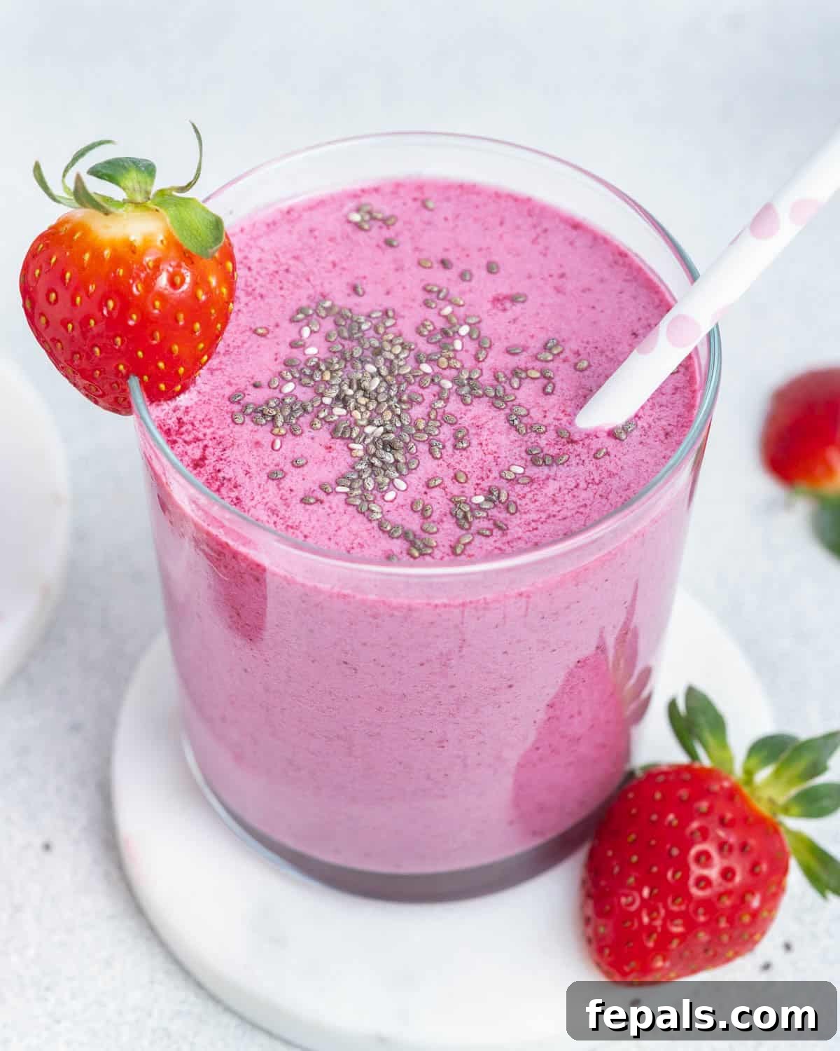 Creamy Strawberry Blueberry Smoothie with Greek Yogurt 2 a cup filled with purple looking smoothie, topped with chia seeds and a straw in the cup.