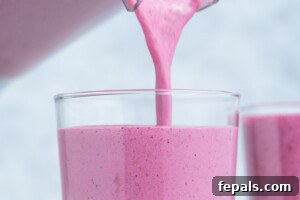 Creamy Strawberry Blueberry Smoothie with Greek Yogurt 12 smoothie being poured into a cup.