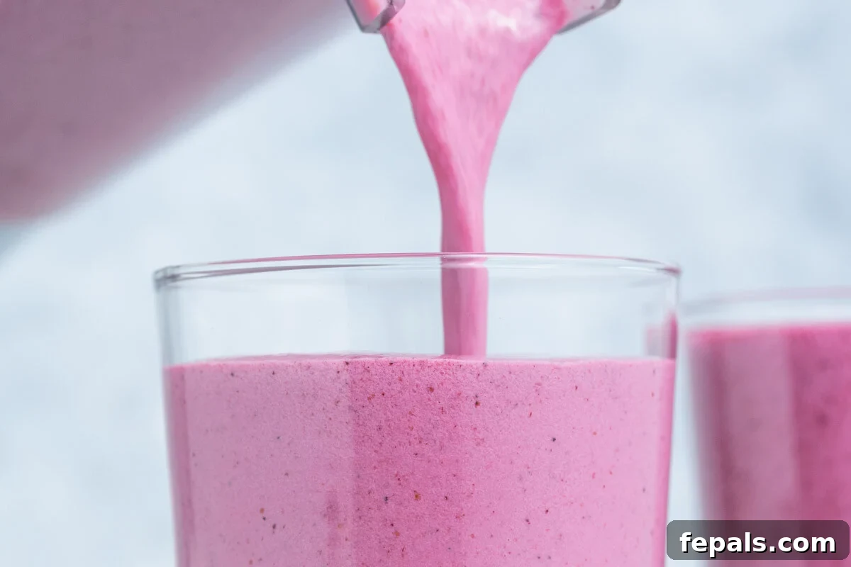 Creamy Strawberry Blueberry Smoothie with Greek Yogurt 7 smoothie being poured into a cup.