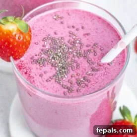 Creamy Strawberry Blueberry Smoothie with Greek Yogurt 9 a cup full of smoothie that purple looking, topped with a sprinkle of chia seeds with a straw in the cup.