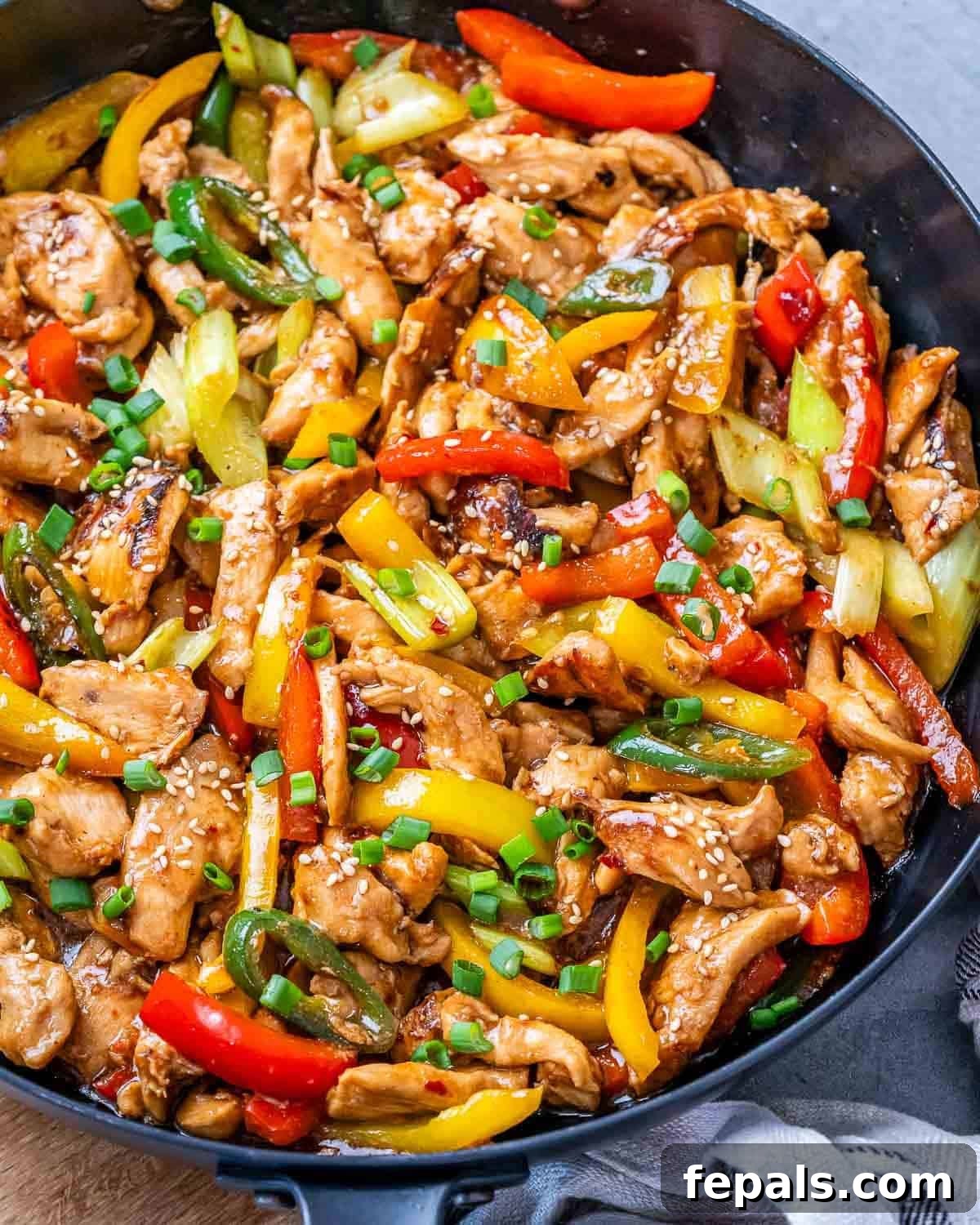 Authentic Hunan Chicken Recipe: Spicy Stir-Fry with Peppers 7 A skillet with sliced chicken, bell peppers and celery in Hunan sauce.