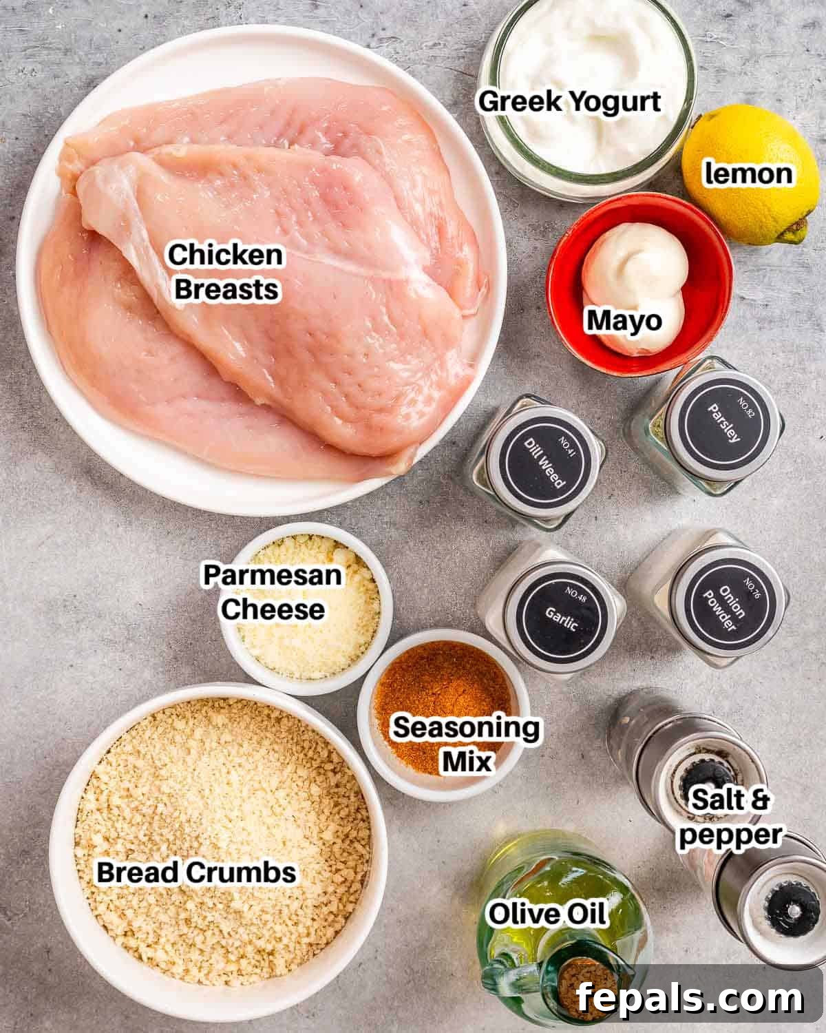 Ingredients for homemade shake and bake chicken arranged on a surface, including chicken, panko, yogurt, and spices.