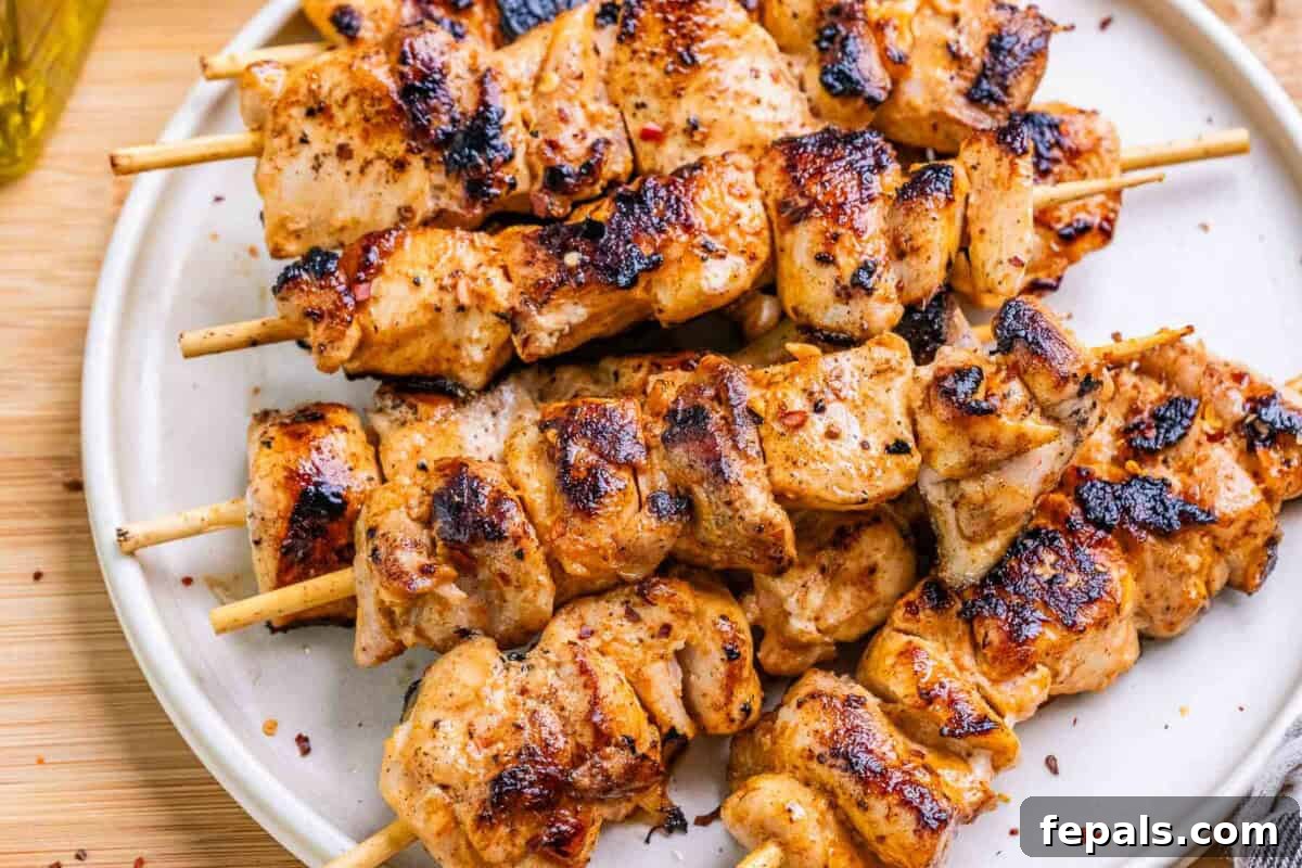 Firecracker Chicken Skewers 6 A close-up shot of grilled chicken skewers on a serving plate.