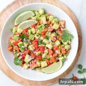 Top BBQ Side Dishes: 18+ Recipes for Summer Gatherings 22 round bowl filled with avocado salsa with lime wedges on them.