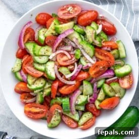Top BBQ Side Dishes: 18+ Recipes for Summer Gatherings 4 salad made from tomatoes, cucumber, and onions in a round white bowl.