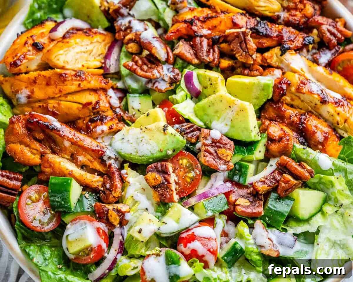 bbq chicken salad in a bowl drizzled with white dressing.