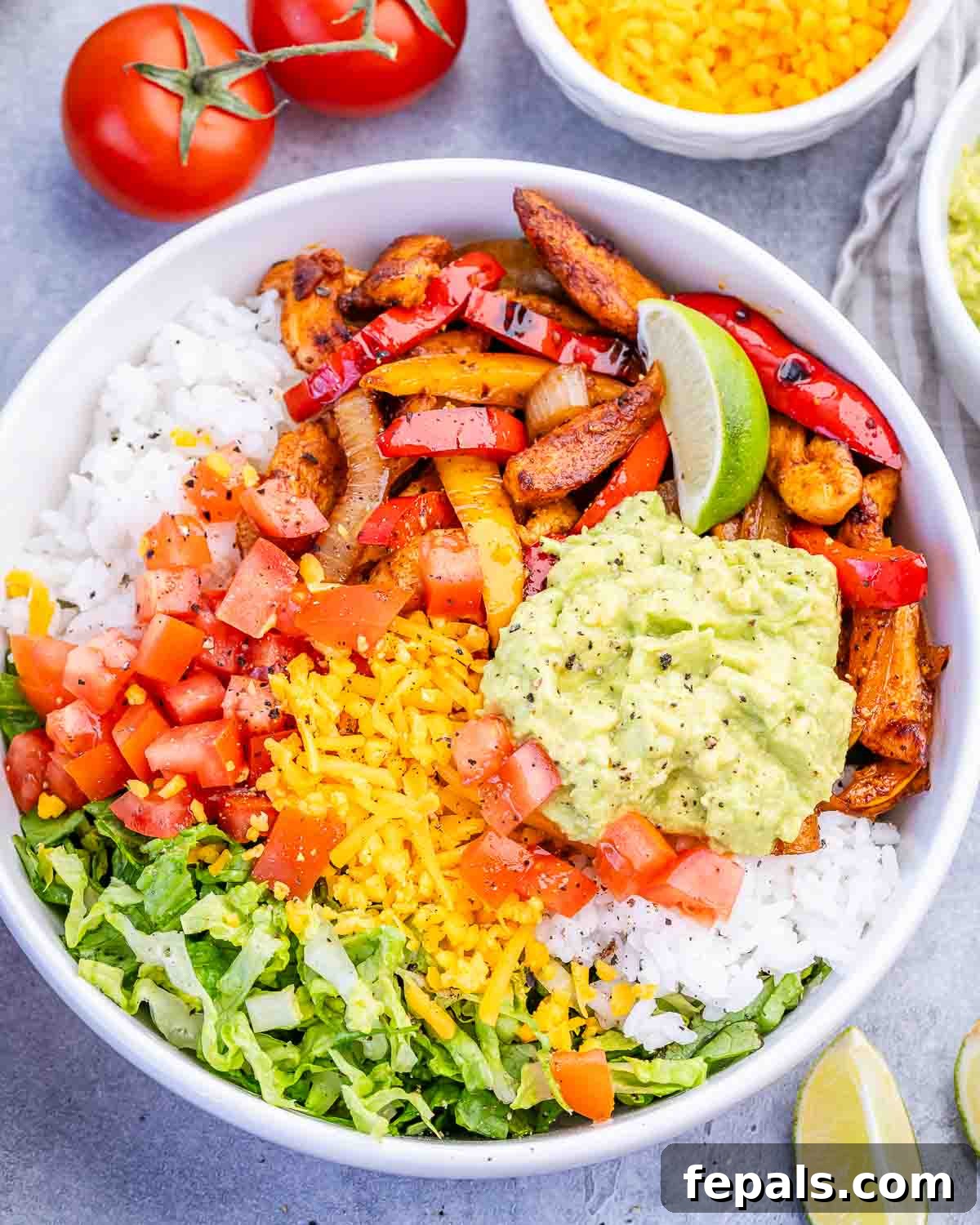 Chicken Fajita Rice Bowl with Peppers & Onions 6 A chicken fajita bowl with avocado, tomato, lettuce and rice.