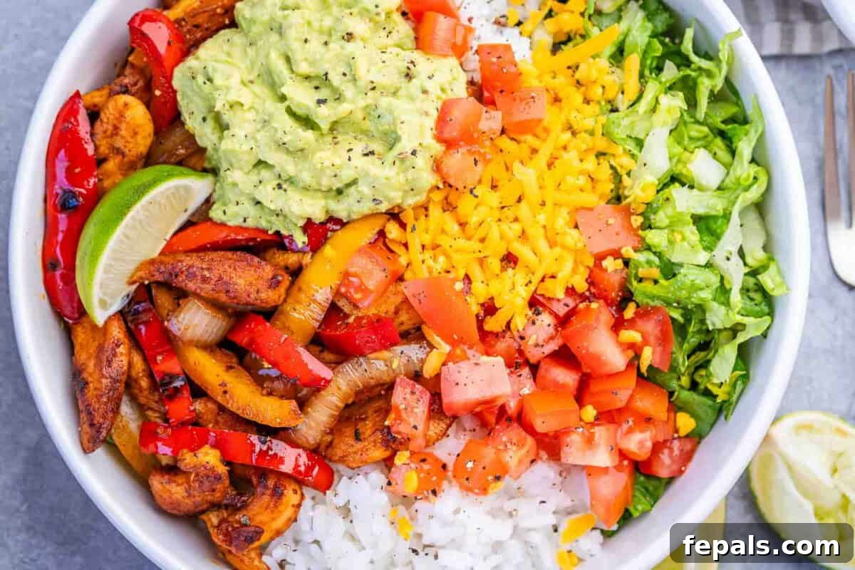 Chicken Fajita Rice Bowl with Peppers & Onions 7 chicken fajita in a bowl with rice, guac, and shredded lettuce.