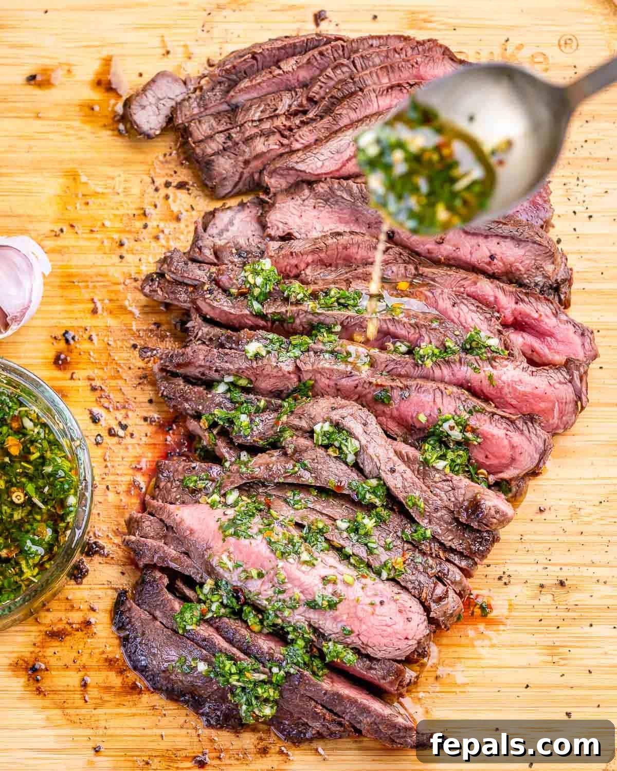 30-Minute Grilled Steak with Fresh Chimichurri Sauce 2 Grilled flank steak being drizzled with chimichurri