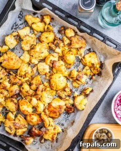 Perfectly roasted and crispy smashed potatoes on a baking sheet.