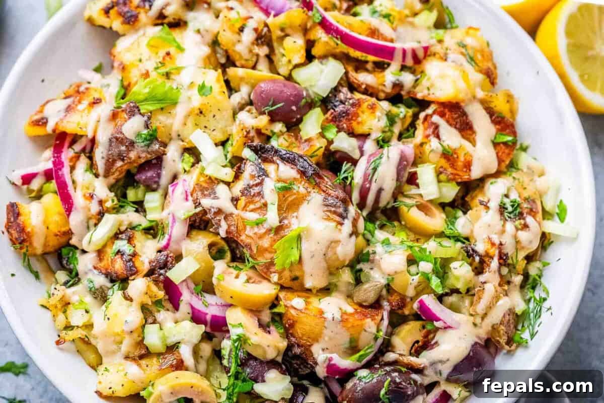 A close-up shot of the finished smashed potato salad in a serving bowl, showcasing the crispy texture of the potatoes.