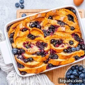 A delicious blueberry French toast bake in a casserole dish, with a golden-brown top and juicy berries.