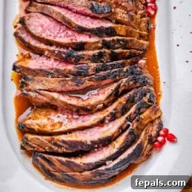 15-Minute Beef Dinners for Busy Weeknights 11 sliced marinated steak on a white plate set in a molasses steak sauce.