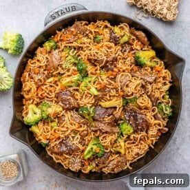 15-Minute Beef Dinners for Busy Weeknights 15 A black and gray skillet with noodles and seared beef and broccoli.