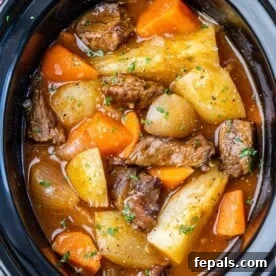 15-Minute Beef Dinners for Busy Weeknights 10 top view of carrots, potatoes, onions, and beef tips in broth inside Crockpot