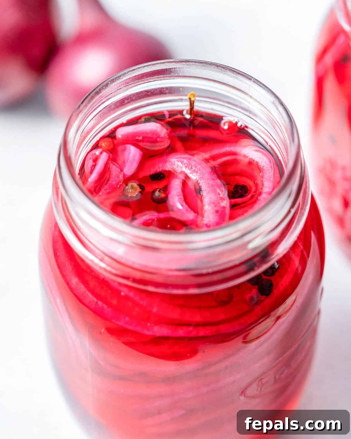 Quick Pickled Red Onions You’ll Prefer Over Store-Bought 7 pickled red onions in a jar with the brine.