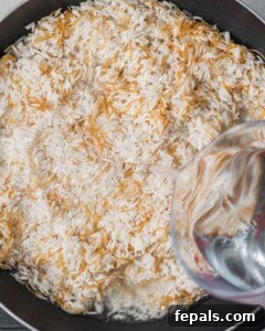 Classic Lebanese Vermicelli Rice 13 Water being poured over the rice and vermicelli mixture in the saucepan.