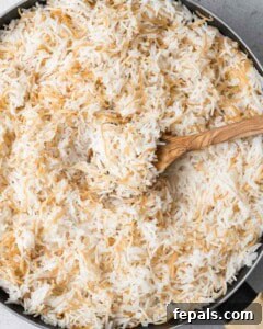 Classic Lebanese Vermicelli Rice 15 A fork fluffing the cooked, fluffy Lebanese rice in the saucepan.