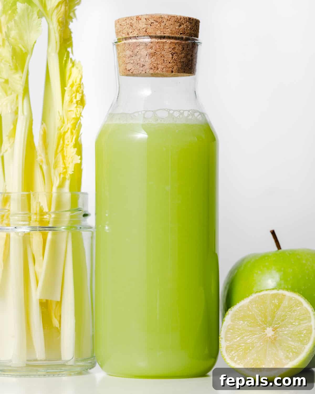 A glass bottle filled with green celery juice, ready for storage.