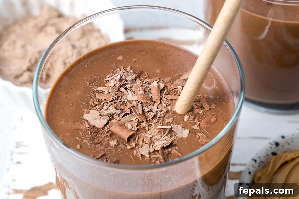a straw in a clear cup with Chocolate Peanut Butter Protein Shake 