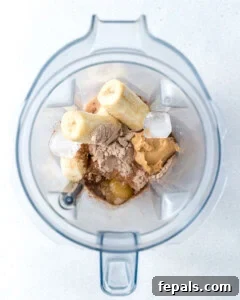 ingredients added to a blender to make peanut butter chocolate protein shake.