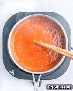 Cooking the enchilada sauce in a pan.