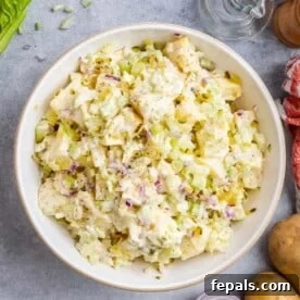 potato salad in a white bowl garnished with black pepper