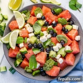 watermelon feta salad in bowl with lime wedges