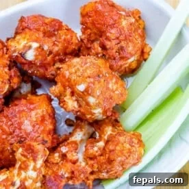 air fried bbq cauliflower wings in a white bowl with celery sticks