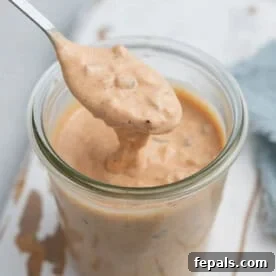 a spoon dipped in a cup full of Big Mac sauce.