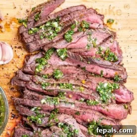 sliced steak topped with chimichurri sauce.