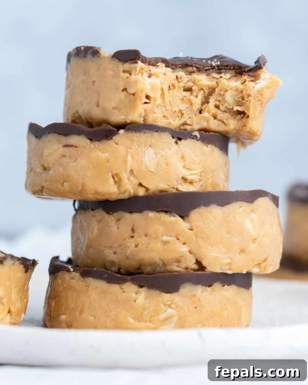 No-Bake Peanut Butter Oat Cups Recipe 2 peanut butter cups stacked over each other with bite taken off the top one.