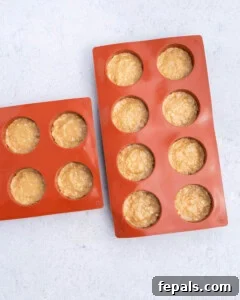 No-Bake Peanut Butter Oat Cups Recipe 12 silicone molds placed in a red silicone mold.