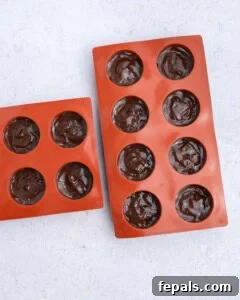 No-Bake Peanut Butter Oat Cups Recipe 14 melted chocolate added over the peanut butter base in a silicone mold.