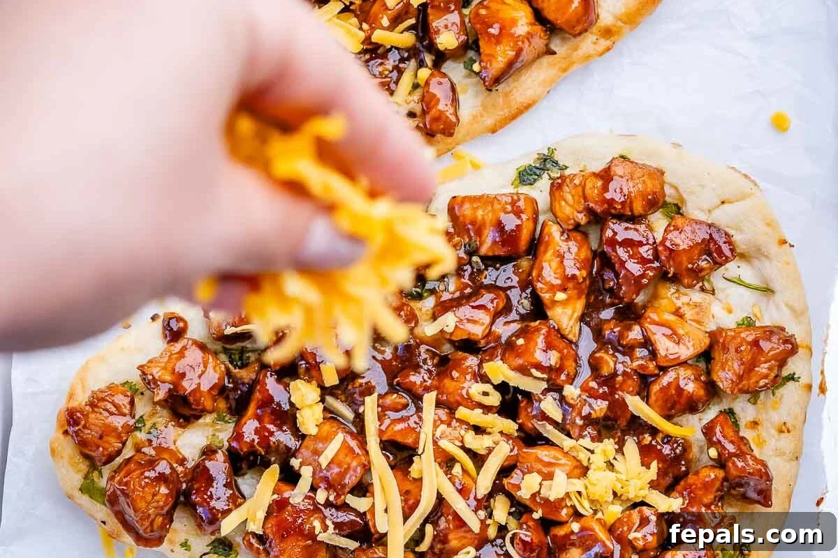 Quick BBQ Chicken Flatbread Recipe for Weeknight Dinner 6 adding shredded cheese over bbq chicken flatbread.