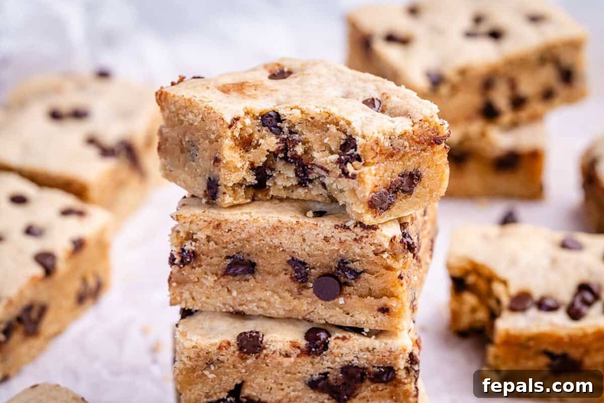 Soft Chewy Chocolate Chip Cookie Bars Recipe 7 cookie bar stacked over each other on a parchment paper.
