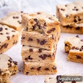Soft Chewy Chocolate Chip Cookie Bars Recipe 9 cookie bars stacked over each other on parchment paper.