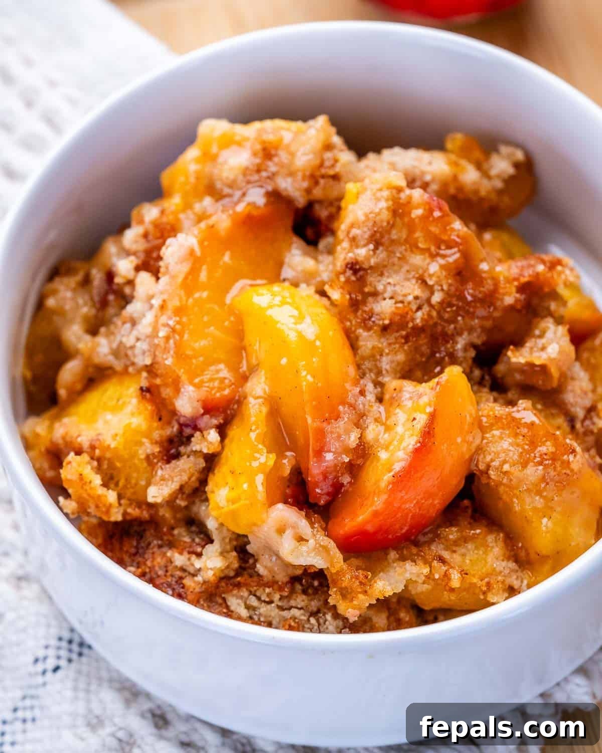 Fresh Peach Dump Cake Recipe with Ripe Peaches 2 A white bowl of peach dump cake