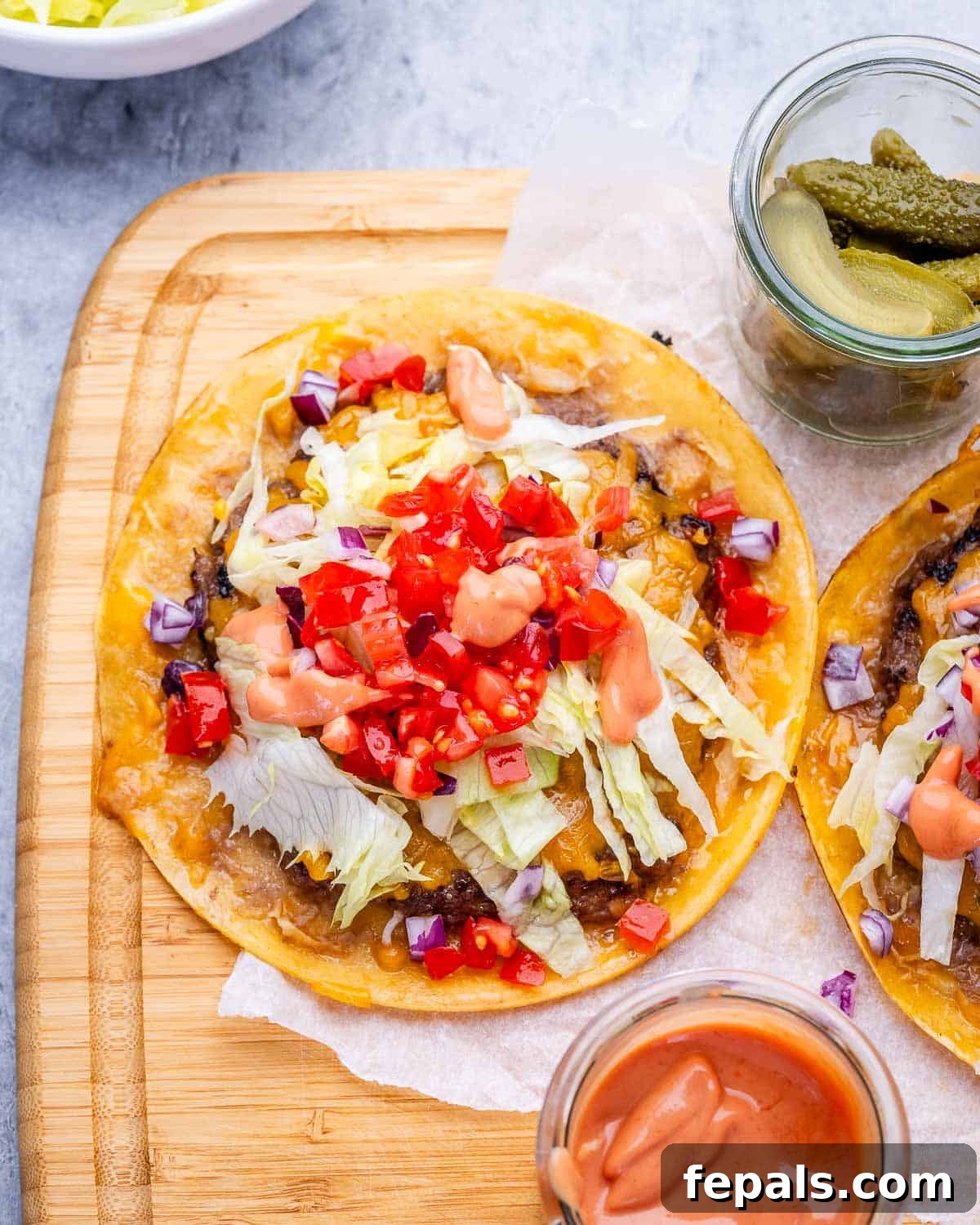 Smash burger tacos on a wooden board.