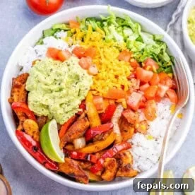 25 Chicken Meal Prep Recipes for Quick, Flavorful Weeknight Meals 3 a bowl with chicken fajitas served with rice, sauteed veggies, and guacamole.