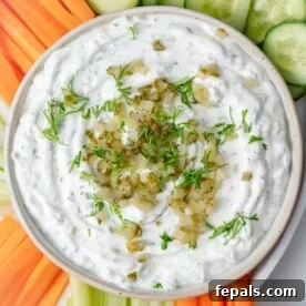 a bowl filled with dill pickle dip made with chopped pickles and greek yogurt and served with fresh veggies.