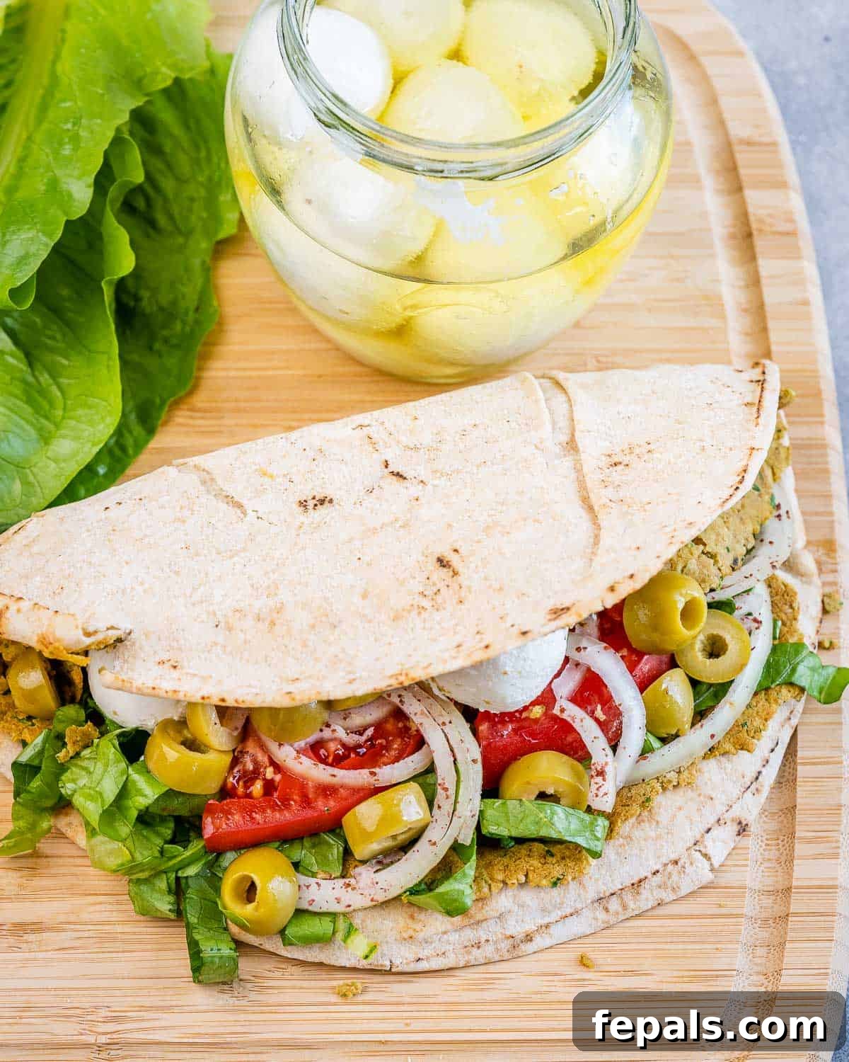 folded smash falafel pita on a cutting board.