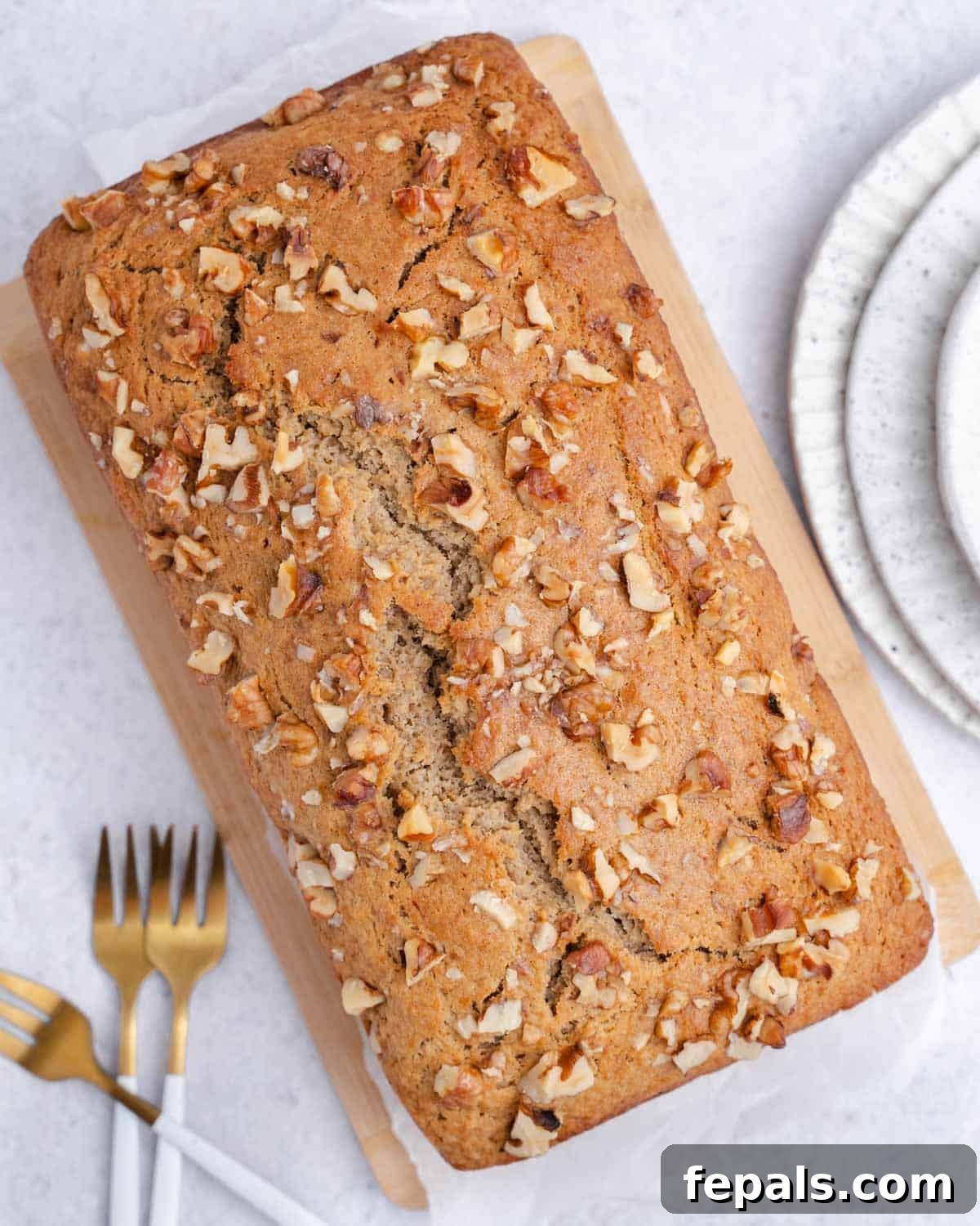 a full whole apple sauce bread topped with chopped walnuts.