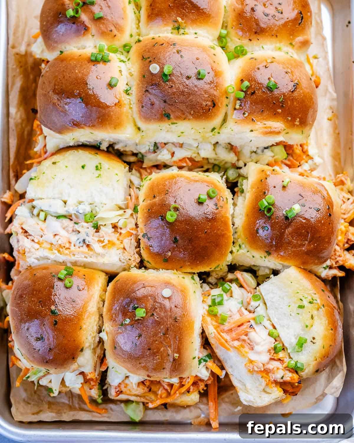 Buffalo chicken sliders with garlic butter on a sheet tray.