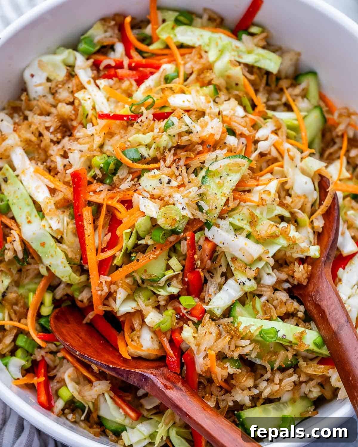 spoon in a bowl filled with crispy rice and veggie salad.