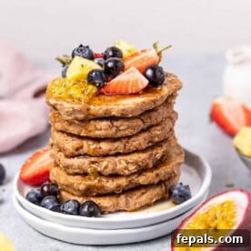 side shot of stacks of pancake topped with fruits